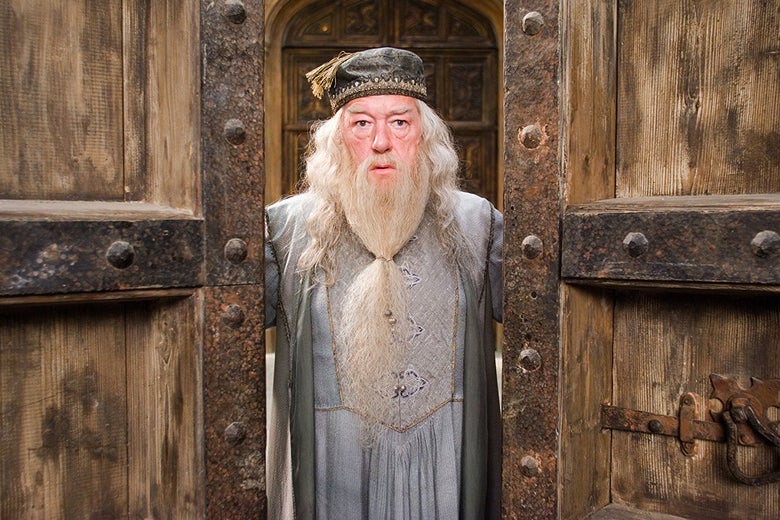 Michael Gambon, as the white-bearded Albus Dumbledore, stands in a doorway